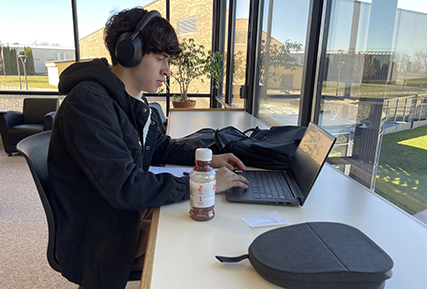 student on laptop in the library.