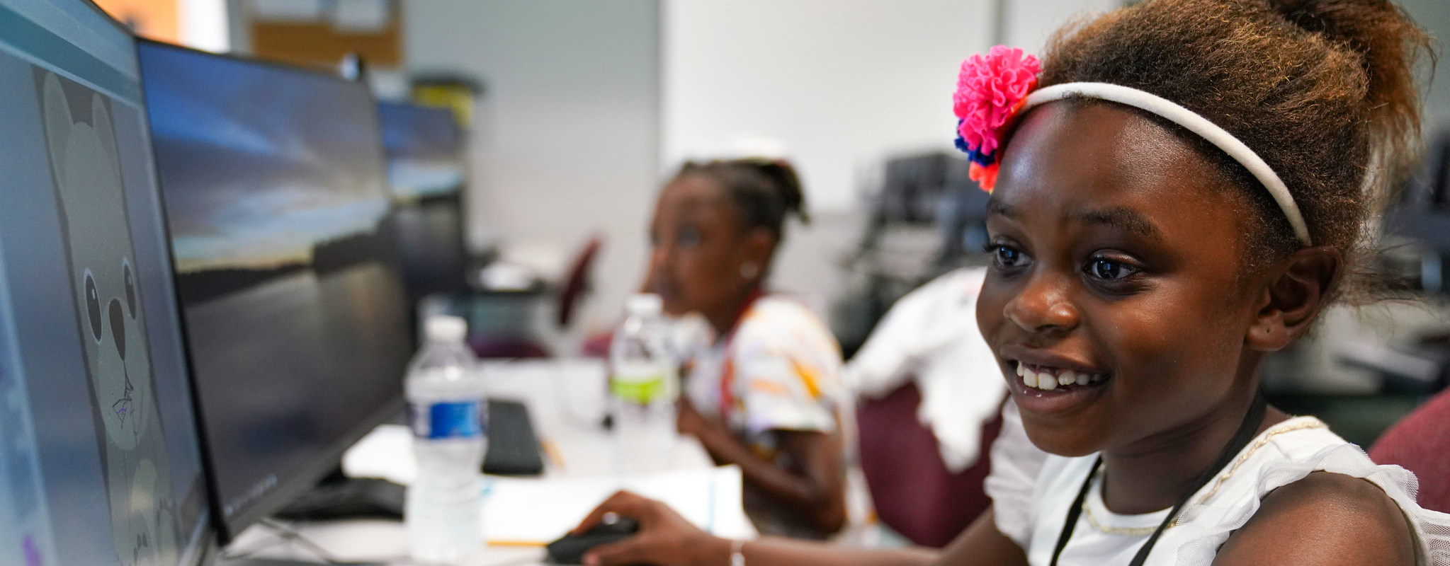 Girl smiling while using a computer.