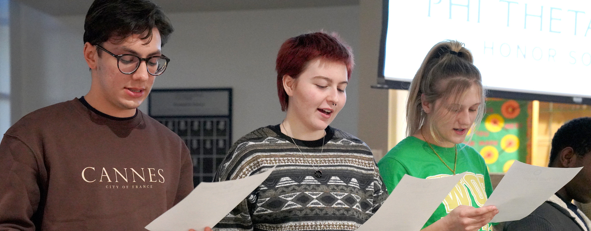 Three students reading a script.