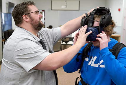 student putting on VR helmet in the law enforcement training center.