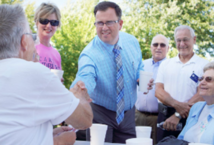 Sandburg President Dr. Reilly shaking hands with a man