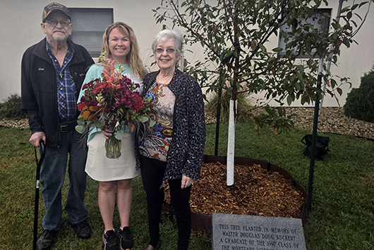 Family of Doug Buckert next to memorial tree.