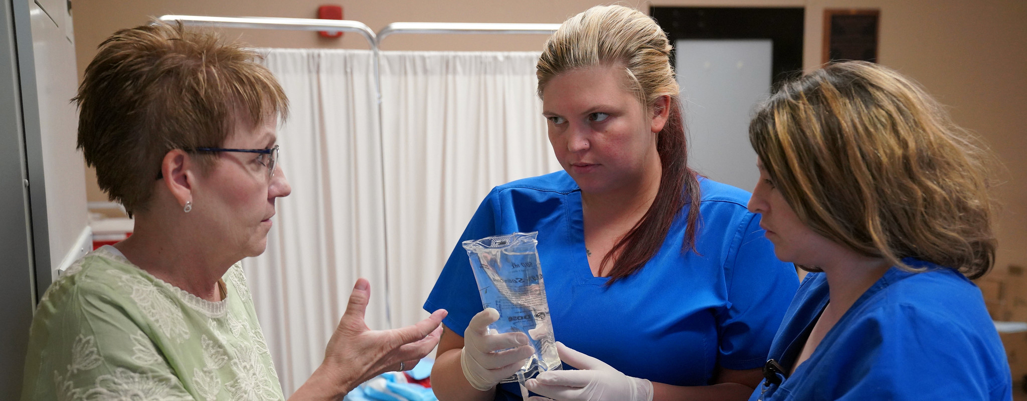 instructor talking to students in nursing lab.