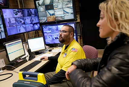public safety officer looking at video screens.