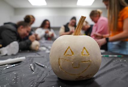 a small pumpkin carved with a face.
