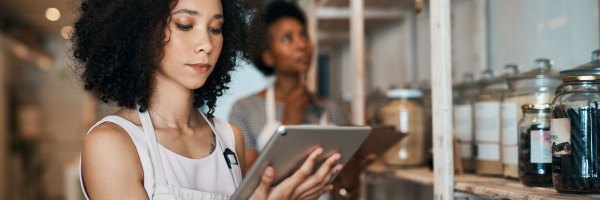 two women taking inventory with a tablet