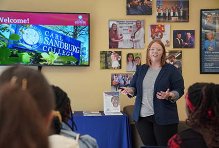 women standing in front of some students talking.