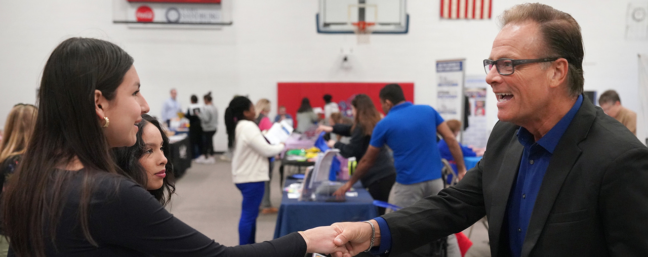 Two students talking to a company rep at the job fair.
