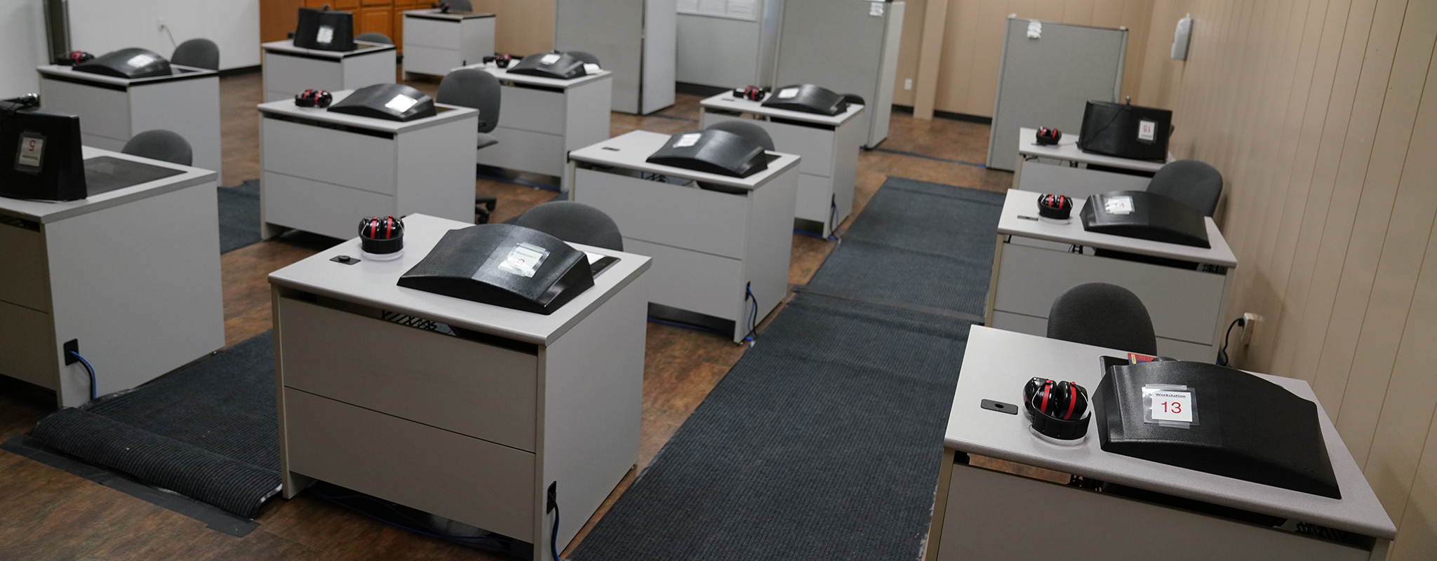 Many computer sitting on a long desk.